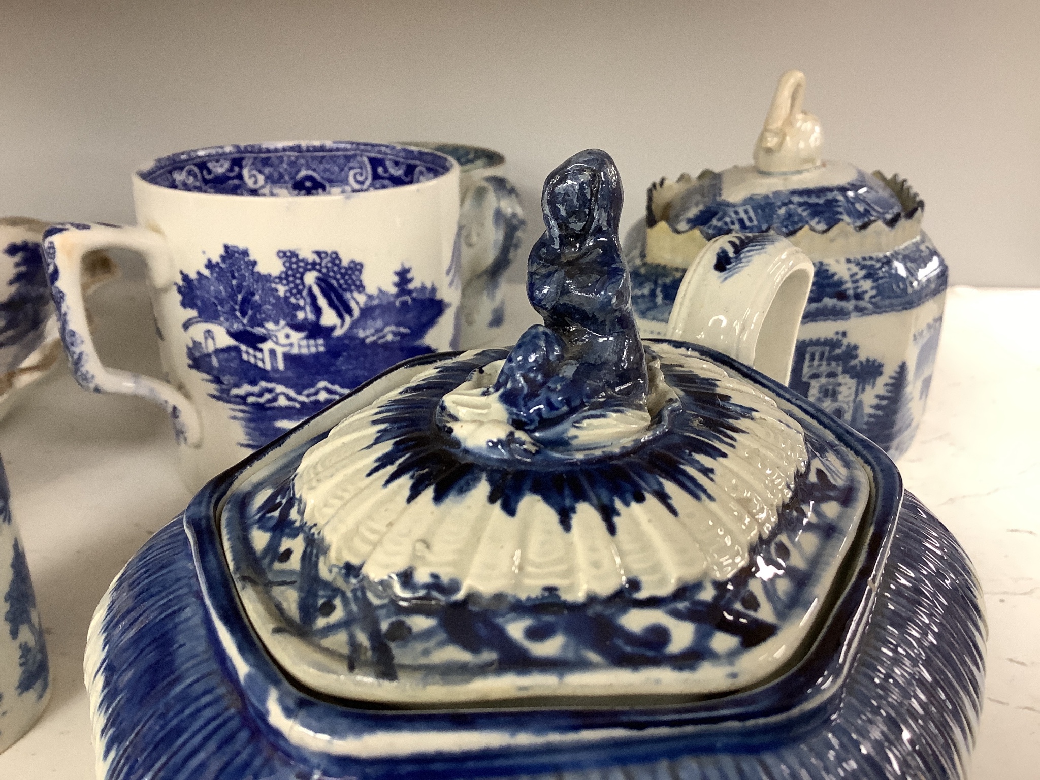 A collection of English blue and white pottery, various dates, comprising a moulded hexagonal teapot and cover, with widow finial, ovoid teapot and cover, lozenge section sugar bowl and cover, with swan finial, circular